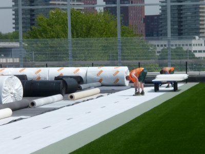 Ontwikkeling van sportvelden met kunstgras op de grond of op het dak. 