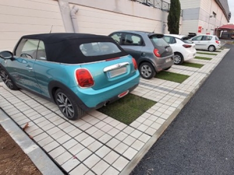 Parking en pavés et gazon d'un centre commercial à Deauville