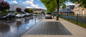 Parking municipal perméable en ville sous la pluie — infiltration des eaux pluviales par dalle alvéolaire OCITY PAV65