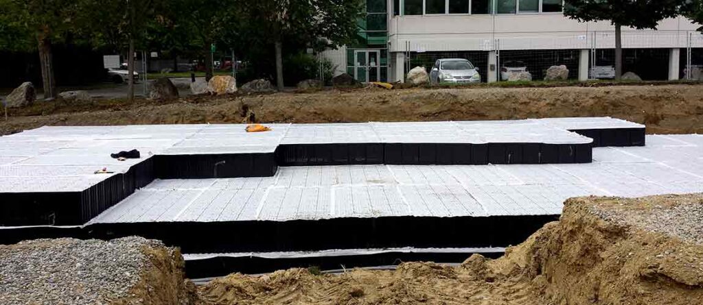 Bassin de rétention enterré modules alvéolaires Nidaplast EP sous parking — gestion eaux pluviales loi Climat