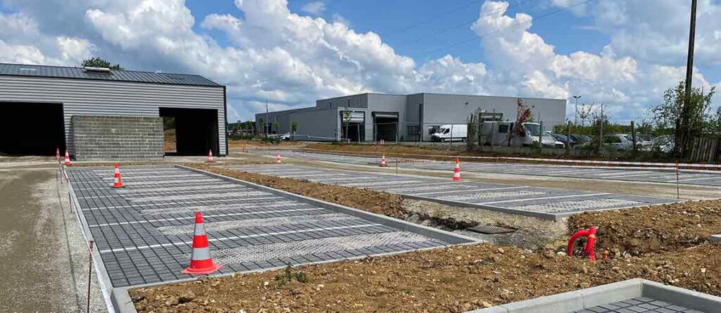 Chantier parking perméable dalles alvéolaires Ocity PAV65 — obligation loi Climat et Résilience 500 m²